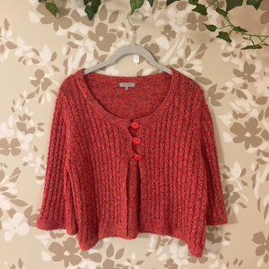 pink knitted cropped shirt with buttons and three quarter length sleeves.